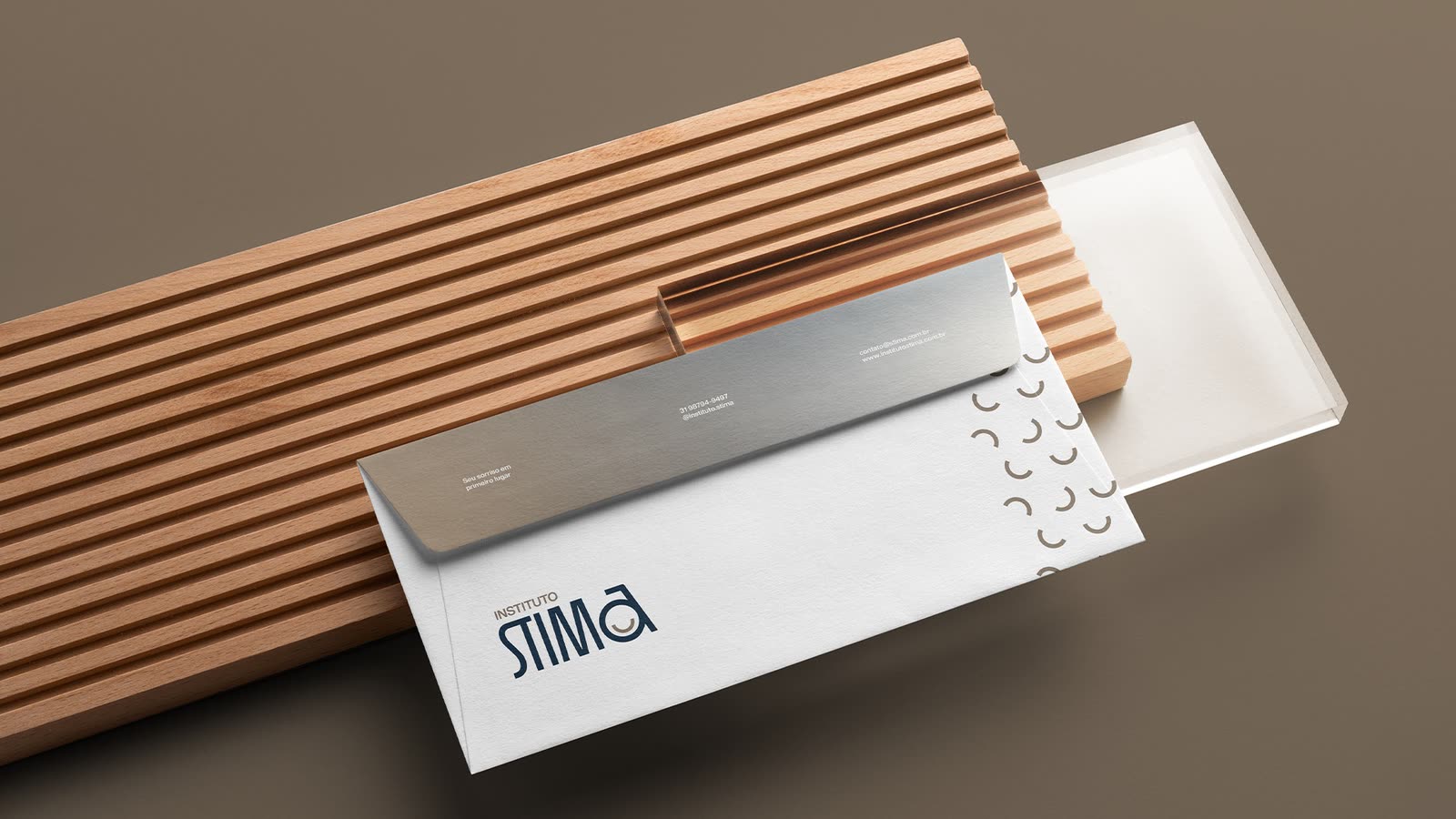 A STIMA envelope with the smile texture on a wooden tray